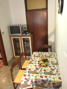 a dining room table with a table cloth with fruit on it at Apartments with a parking space Smrika, Kraljevica - 5338 in Šmrika