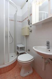Studio Punat 5410a في بونات: حمام مع مرحاض ومغسلة ودش