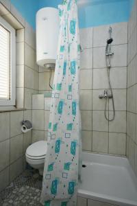 een badkamer met een toilet en een douchegordijn bij Apartments with a parking space Novi Vinodolski - 5526 in Novi Vinodolski