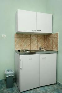 een keuken met witte kasten en een wastafel bij Apartments with a parking space Novi Vinodolski - 5526 in Novi Vinodolski