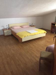 een slaapkamer met een bed met gele lakens en een houten vloer bij Apartments with a parking space Novi Vinodolski - 5526 in Novi Vinodolski