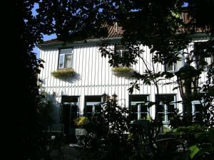 un edificio blanco con ventanas y cajas de flores. en Leisewitz' Garten, en Celle