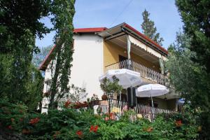 a building with umbrellas in front of it at Apartments with parking space Selce, Crikvenica - 5531 in Selce