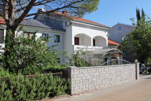 a white house with a fence in front of it at Apartments with a parking space Malinska (Krk) - 5353 in Vantačići