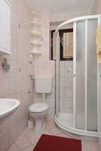 a white bathroom with a toilet and a shower at Apartments with a parking space Malinska (Krk) - 5353 in Vantačići