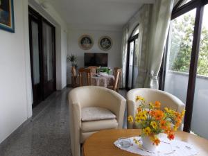 a living room with two chairs and a table with flowers on it at Apartments with a parking space Malinska (Krk) - 5353 in Vantačići