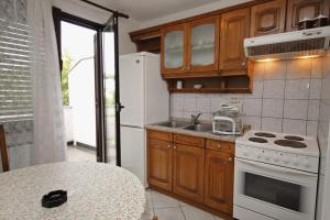 a kitchen with a white stove and a sink at Apartments with a parking space Malinska (Krk) - 5353 in Vantačići