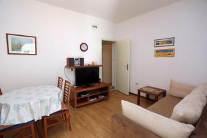 a living room with a couch and a tv at Apartments with a parking space Supetar, Brac - 5385 in Supetar