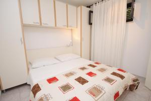 a small bedroom with a bed in a room at Apartments with a parking space Supetar, Brac - 5385 in Supetar