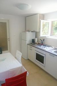 a kitchen with a white refrigerator and a stove top oven at Apartment Selce 5531b in Selce