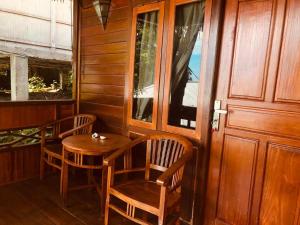 a room with a table and chairs and a door at Panorama Cottage in Bunaken