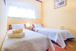 sypialnia z 2 łóżkami z białą pościelą i oknem w obiekcie Apartments with a parking space Malinska (Krk) - 5456 w mieście Vantačići