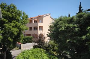 a building with trees in front of it at Apartments with a parking space Malinska (Krk) - 5456 in Vantačići