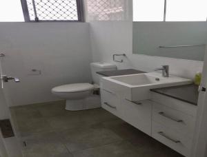 a white bathroom with a toilet and a sink at Oceanic 19 - linen not included in Forster +7 photos