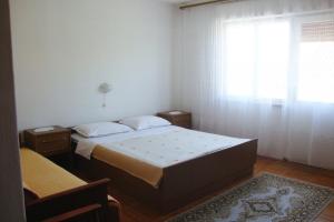 a bedroom with a large bed and a window at Apartments with a parking space Baska, Krk - 5407 in Baška