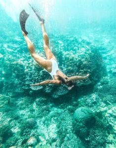 a woman is swimming in the water at Sasak Island Bungalows in Gili Meno