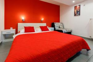 a red bedroom with a large bed and a chair at Studio Crikvenica 5478b in Crikvenica