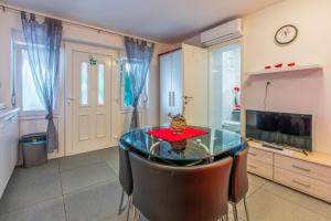 a dining room with a glass table and a television at Studio Crikvenica 5478b in Crikvenica