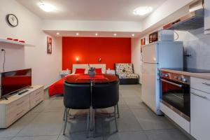 a kitchen with a table and a red wall at Studio Crikvenica 5478b in Crikvenica