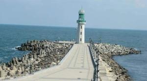 a lighthouse on a pier in the water at العربية العالمية للسياحة و الرحلات شقق فندقية فاخرة برأس البر in ‘Izbat al Burj