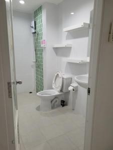 La salle de bains blanche est pourvue de toilettes et d'un lavabo. dans l'établissement B&B NAMO PHUKET, à Kathu