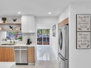 a white kitchen with a refrigerator and a sink at 5-star Lakefront Oasis In Hollywood-Hard rock casino in Fort Lauderdale