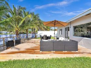 eine Holzterrasse mit Tisch und Sonnenschirm in der Unterkunft 5-star Lakefront Oasis In Hollywood-Hard rock casino in Fort Lauderdale