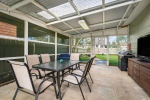 a screened in patio with a table and chairs at Panoscape in Sunset Strip