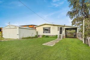 a white house with a fence and a yard at Panoscape in Sunset Strip