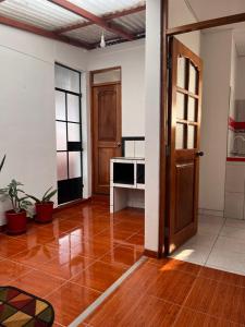 an empty room with wooden floors and a door at Hospedaje Familiar Laos in Oxapampa