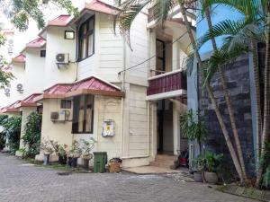 ein Gebäude mit Palmen davor in der Unterkunft Graha Ara Homestay Syariah RSUD Dr Soetomo Surabaya Mitra RedDoorz in Surabaya