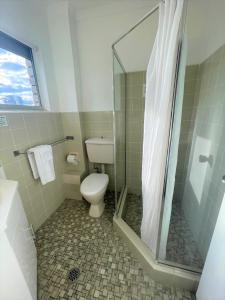 a bathroom with a toilet and a shower at Forster Motor Inn in Forster