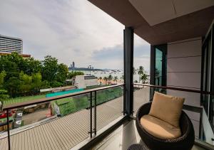 a balcony with a chair and a view of the ocean at Serenotel Pattaya in Pattaya Central
