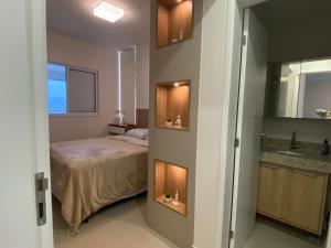 a small bedroom with a bed and a sink at Apartamento em Bertioga com varanda gourmet in Bertioga +18 photos