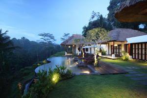 uma villa com um jardim à noite em Villa Amrita em Ubud