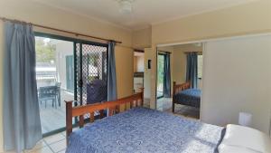 a bedroom with a bed and a balcony at 20 Orania Court in Rainbow Beach