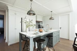 a kitchen with a large island with bar stools at Paradise Beach 3 Bedroom Luxury Accommodation in Papamoa
