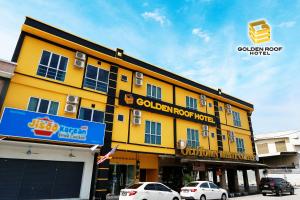 a yellow building with cars parked in front of it at Golden Roof Hotel Falim Ipoh in Ipoh
