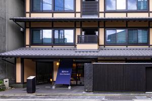 un bâtiment avec un panneau bleu devant lui dans l'établissement Rinn Gion Shirakawa, à Kyoto