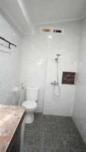 y baño con aseo y ducha. en Mulia Home Stay, en Nusa Dua