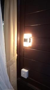 a light on a wooden wall next to a window at Mulia Home Stay in Nusa Dua
