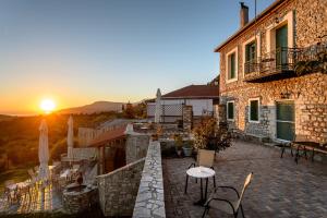 a building with a table and a sunset in the background at Gerofotis Traditional Guesthouse est 1892 - Close to Aigio, Akoli, Selianitika in Lákka