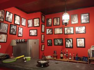 Cette chambre est dotée d'un mur rouge avec des photos. dans l'établissement Shalana Homestay- formerly Teka Teki House, à Seminyak 32 autres photos