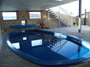 a swimming pool in a building with a staircase at Solaz del Ambroz in Jarilla