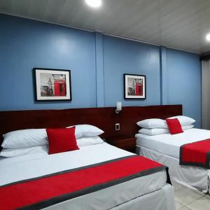 2 camas en una habitación con paredes azules en Hotel Boutique Malibu Los Sueños en Tigre
