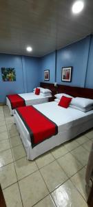 três camas num quarto com paredes azuis em Hotel Boutique Malibu Los Sueños em Tigre