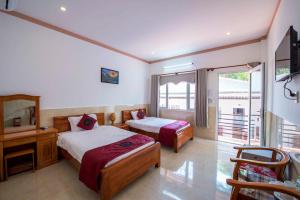 a hotel room with two beds and a television at Ngoc Hanh Bungalow Phu Quoc in Phu Quoc