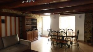 a living room with a table and chairs and a couch at Gite Notre Dame in Pontorson