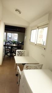 a room with white tables and chairs and windows at Gite Notre Dame in Pontorson