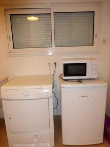 a small kitchen with a microwave and a refrigerator at Gite Notre Dame in Pontorson